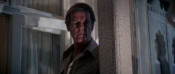 Movie still from “Octopussy” (1983), directed by John Glen – A person standing next to a wall; Close Up shot, Low angle