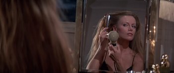 Movie still from “Octopussy” (1983), directed by John Glen – A woman brushing her hair in front of a mirror; Close Up shot, Over the shoulder angle