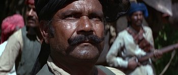 Movie still from “Octopussy” (1983), directed by John Glen – An old man with a mustache and a beard; Close Up shot, Low angle