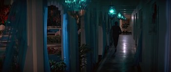 Movie still from “Octopussy” (1983), directed by John Glen – A person walking down a hallway in a building; Wide shot, High angle