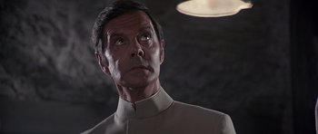 Movie still from “Octopussy” (1983), directed by John Glen – A person wearing a suit and tie; Close Up shot, Low angle