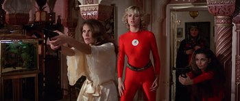 Movie still from “Octopussy” (1983), directed by John Glen – A woman in a white dress standing next to a woman in a red costume; Medium shot, Low angle