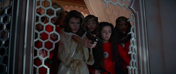 Movie still from “Octopussy” (1983), directed by John Glen – A group of women holding a remote control in their hands; Medium shot, Low angle