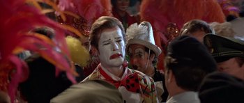 Movie still from “Octopussy” (1983), directed by John Glen – A group of people dressed up as clowns; Close Up shot, Over the shoulder angle
