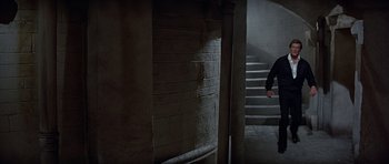 Movie still from “Octopussy” (1983), directed by John Glen – A man walking down a set of stairs; Wide shot, High angle