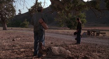 Movie still from “Of Mice and Men” (1992), directed by Gary Sinise – Two men standing next to each other near a tree; Wide shot, Low angle