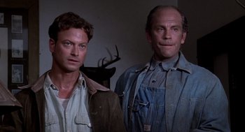 Movie still from “Of Mice and Men” (1992), directed by Gary Sinise – Two men standing next to each other in front of a wall; Close Up shot, Low angle