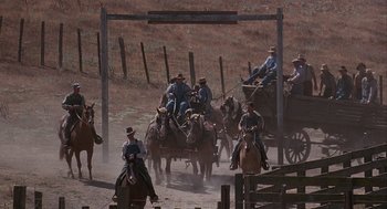 Movie still from “Of Mice and Men” (1992), directed by Gary Sinise – A group of men riding on the backs of horses; Wide shot, High angle