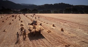 Movie still from “Of Mice and Men” (1992), directed by Gary Sinise – A group of people in the middle of a field; Extreme Wide shot, High angle