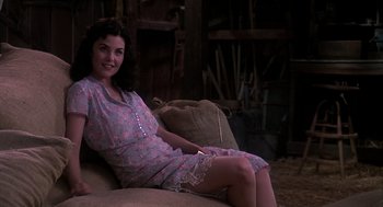 Movie still from “Of Mice and Men” (1992), directed by Gary Sinise – A woman sitting on top of a couch in a room; Medium shot, High angle
