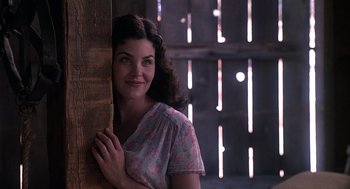 Movie still from “Of Mice and Men” (1992), directed by Gary Sinise – A woman leaning against a wooden wall with her hand on the wall; Close Up shot, Low angle