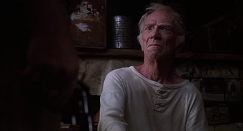 Movie still from “Of Mice and Men” (1992), directed by Gary Sinise – An older man in a white shirt is looking at the camera; Close Up shot, Low angle