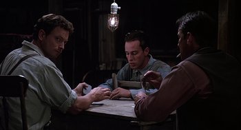 Movie still from “Of Mice and Men” (1992), directed by Gary Sinise – A group of men sitting at a table playing cards; Medium shot, Over the shoulder angle