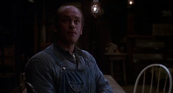 Movie still from “Of Mice and Men” (1992), directed by Gary Sinise – A man in a blue overalls is looking at the camera; Medium shot, Low angle