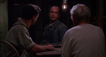 Movie still from “Of Mice and Men” (1992), directed by Gary Sinise – A man is looking at himself in the mirror; Medium shot, Over the shoulder angle