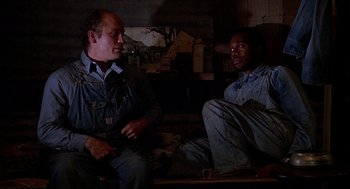 Movie still from “Of Mice and Men” (1992), directed by Gary Sinise – A couple of men sitting next to each other on a couch; Medium shot, Low angle
