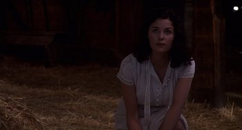 Movie still from “Of Mice and Men” (1992), directed by Gary Sinise – A woman sitting on the ground in a barn; Medium shot, High angle