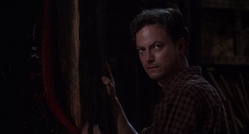 Movie still from “Of Mice and Men” (1992), directed by Gary Sinise – A man standing in a dark room with his hand up to his face; Close Up shot, Low angle