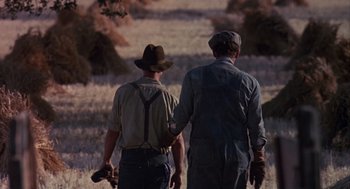 Movie still from “Of Mice and Men” (1992), directed by Gary Sinise – A couple of men walking across a field; Medium shot, Over the shoulder angle