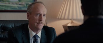 Movie still from “Office Christmas Party” (2016), directed by Will Speck – An older man wearing a suit and tie with a mustache; Close Up shot, Over the shoulder angle