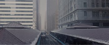 Movie still from “Office Christmas Party” (2016), directed by Will Speck – A train traveling down the train tracks in a city; Extreme Wide shot, High angle