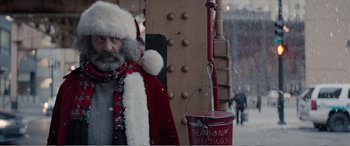 Movie still from “Office Christmas Party” (2016), directed by Will Speck – A man dressed as santa claus standing next to a red bucket; Medium shot, Over the shoulder angle