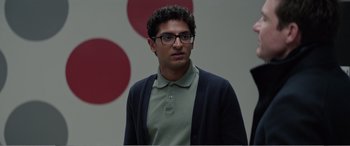 Movie still from “Office Christmas Party” (2016), directed by Will Speck – A young man wearing glasses and a sweater; Close Up shot, Over the shoulder angle