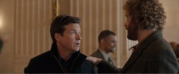 Movie still from “Office Christmas Party” (2016), directed by Will Speck – Two men talking to each other in front of a building; Medium shot, Over the shoulder angle