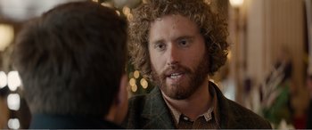 Movie still from “Office Christmas Party” (2016), directed by Will Speck – A person with curly hair and a beard; Close Up shot, Over the shoulder angle