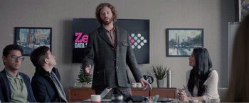 Movie still from “Office Christmas Party” (2016), directed by Will Speck – A man in a suit is standing in front of a desk; Medium shot, Over the shoulder angle