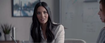 Movie still from “Office Christmas Party” (2016), directed by Will Speck – A woman with long black hair sitting on a couch; Close Up shot, Over the shoulder angle