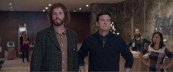 Movie still from “Office Christmas Party” (2016), directed by Will Speck – Two men standing next to each other in a room; Medium shot, Over the shoulder angle