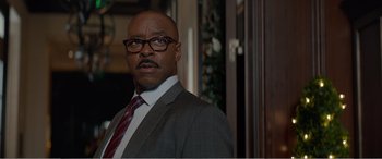 Movie still from “Office Christmas Party” (2016), directed by Will Speck – A man in a suit and tie standing in front of a window; Close Up shot, Low angle