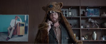 Movie still from “Office Christmas Party” (2016), directed by Will Speck – A man in a bear costume talking on a phone; Medium shot, Low angle