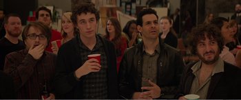 Movie still from “Office Christmas Party” (2016), directed by Will Speck – Two young men standing next to each other holding drinks; Medium shot, Over the shoulder angle