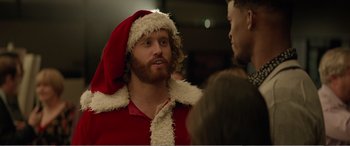 Movie still from “Office Christmas Party” (2016), directed by Will Speck – A bearded man wearing a santa clause hat; Close Up shot, Over the shoulder angle