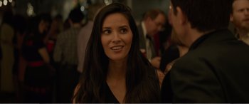 Movie still from “Office Christmas Party” (2016), directed by Will Speck – A woman with long black hair smiling at the camera; Close Up shot, Over the shoulder angle