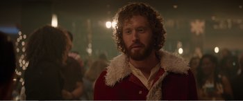 Movie still from “Office Christmas Party” (2016), directed by Will Speck – A man with a beard and curly hair wearing a red jacket; Close Up shot, Over the shoulder angle