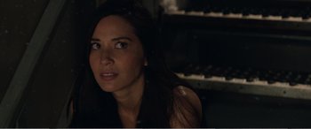 Movie still from “Office Christmas Party” (2016), directed by Will Speck – A woman with long black hair is looking at the camera; Close Up shot, Over the shoulder angle