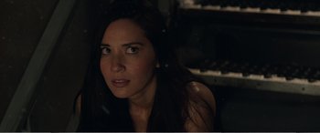 Movie still from “Office Christmas Party” (2016), directed by Will Speck – A woman with long dark brown hair looking at the camera; Close Up shot, Over the shoulder angle