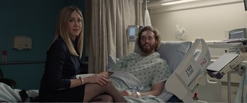 Movie still from “Office Christmas Party” (2016), directed by Will Speck – A woman sitting next to a man in a hospital bed; Medium shot, Over the shoulder angle