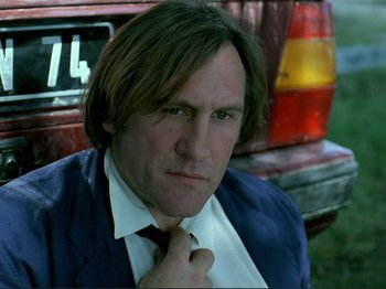 Movie still from “Oh, Woe Is Me” (1993), directed by Jean-Luc Godard – A person wearing a suit and tie; Close Up shot, Low angle