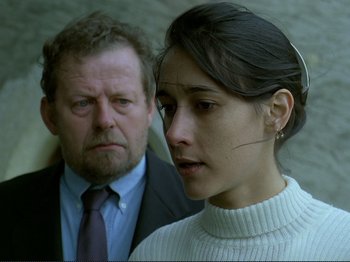 Movie still from “Oh, Woe Is Me” (1993), directed by Jean-Luc Godard – A man and a woman standing next to each other; Close Up shot, Over the shoulder angle