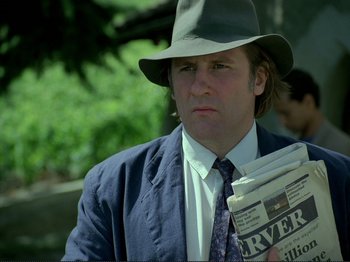 Movie still from “Oh, Woe Is Me” (1993), directed by Jean-Luc Godard – A man in a hat holding a newspaper; Close Up shot, Low angle