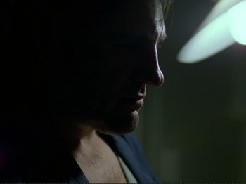 Movie still from “Oh, Woe Is Me” (1993), directed by Jean-Luc Godard – A person's face in the dark; Close Up shot, Low angle