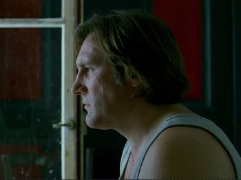 Movie still from “Oh, Woe Is Me” (1993), directed by Jean-Luc Godard – A person looking out a window; Close Up shot, Low angle