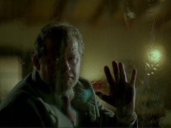 Movie still from “Oh, Woe Is Me” (1993), directed by Jean-Luc Godard – A man in a jacket is holding out his hand; Close Up shot, Low angle