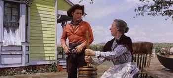 Movie still from “Oklahoma!” (1955), directed by Fred Zinnemann – An old woman and a man in cowboy attire; Medium shot, Low angle