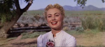 Movie still from “Oklahoma!” (1955), directed by Fred Zinnemann – A woman with blonde hair is smiling for the camera; Close Up shot, Low angle