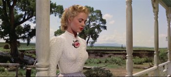 Movie still from “Oklahoma!” (1955), directed by Fred Zinnemann – A beautiful blonde woman in a white blouse; Medium shot, Low angle